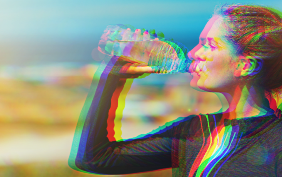 Woman drinking water from a transparent water bottle
